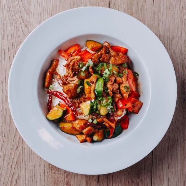Hornbill Sushi & Asian Fusion's Kung Pao Chicken with rice, zucchini, red peppers, and scallions.