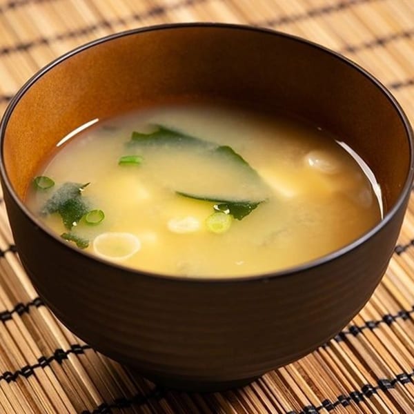 A bowl of Hornbill Sushi & Asian Fusion's miso soup with tofu, seaweed, and green onions.