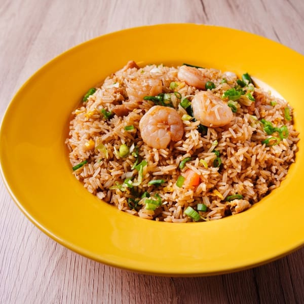Hornbill Sushi & Asian Fusion's shrimp fried rice with green onions in a yellow bowl.
